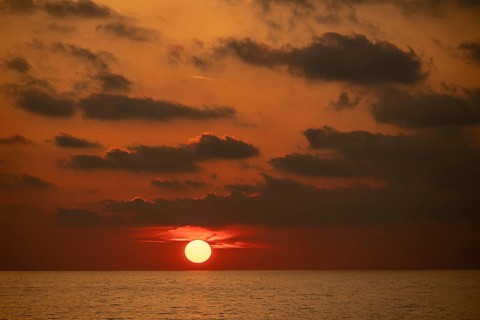 Sunset bathes the sky and clouds in shades of red and orange, Aeolian or Lipari Islands, Southern