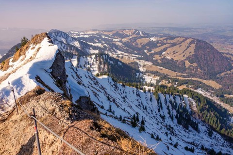 Snowy mountain peaks with a wide panorama of the surrounding alpine region under clear skies,