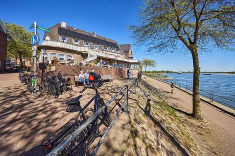 Rhine river, Rheinterrassen Rees restaurant, brick building, waterfront, metal railings, bicycles,