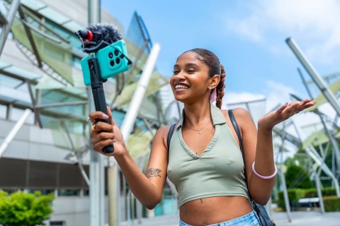 Young content creator recording video for her channel, actively engaging with her audience using a