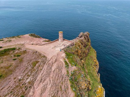 Aerial view of the rocky cliffs at Cap Fréhel with the historic Vauban lighthouse, 17th century