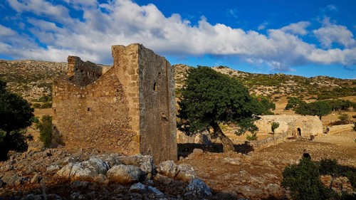 Agios Georgios monastery and church, dilapidated stone structures with trees and rocks in rural
