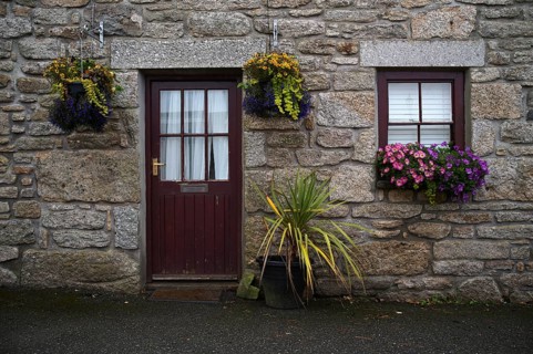 Façade with flower boxes and hanging baskets, residential building, St Just in Penwith, Cornwall,