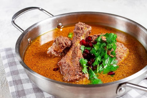 Fesenjan, an Iranian dish, stewed chicken, in a nut-pomegranate sauce, in a saucepan, light