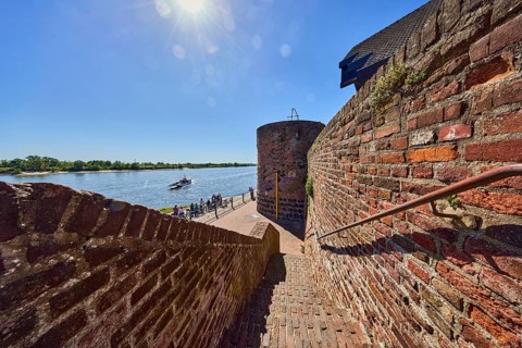 Rhine river, brick wall, brick staircase, metal railing, tower, sun backlight, blue sky, cloudless,