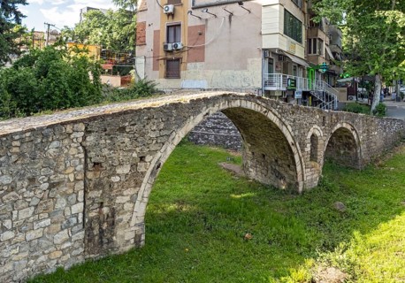 Tanners' Bridge - historic Ottoman-era stone footbridge - surrounded by green grass and city
