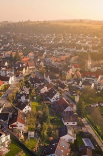Panoramic view of a village with densely arranged houses and a church tower, Deufringen, Aidlingen,
