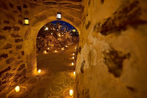 Open-air cinema, a stone archway at night with warm light from lanterns along the way, Kastro, old