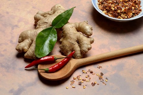 Ginger, ginger root with kaffir lime leaf and chili pepper and chilli flakes in pot