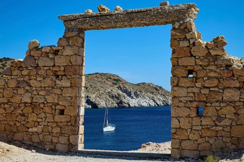 Stone ruin with sailboat on blue sea in the background, Palio Ergostasio Kaolini, Old Kaolin