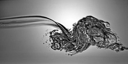 A small longitudinal wave frozen by short exposure in crystal-clear water in the photo studio