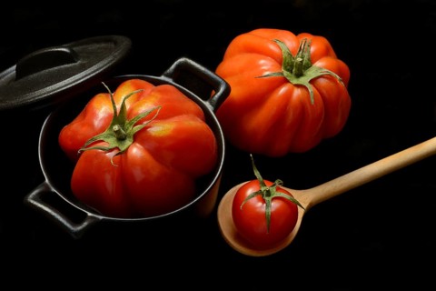 Tomatoes in pots and cooking spoon, Solanum lycopersicum