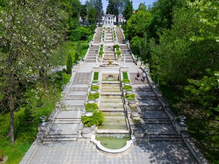 A large park with symmetrical stairs and central fountains surrounded by trees and gardens aerial