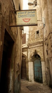 A narrow alley with a sign from a dentist between old, mysterious buildings in the old town, Medina