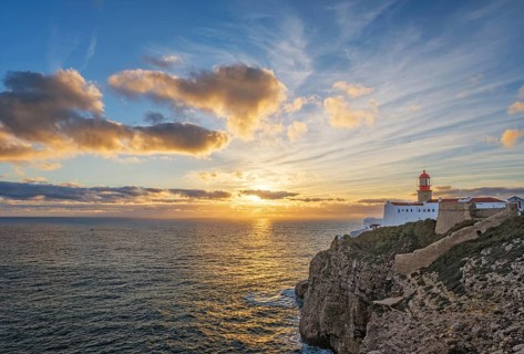 View of the Lighthouse of Cabo de Sao Vicente in Sagres, Algarve, Portugal, at sunset with ocean