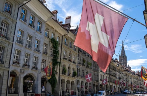 Swiss national flag, Gerechtigkeitsgasse with historic houses, old town, Bern, Canton of Bern,