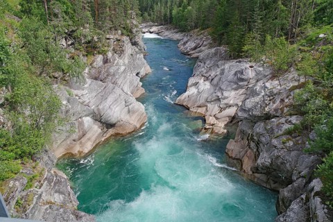 A turquoise river flows through a rocky gorge surrounded by green forests, rafting, Sjoa, Vinstra,