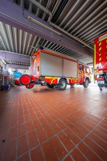 Interior of a fire department garage with several red vehicles and industrial equipment, Gechingen