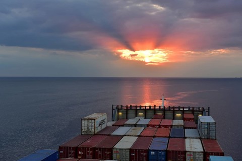 Container ship sails at sunset on the Baltic Sea, Riga, Latvia