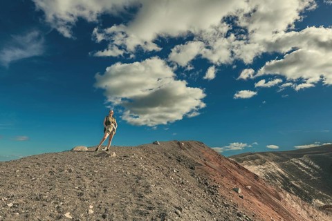 Portrait of a female tourist at the summit of the Cerro Negro volcano. Lifestyle of a girl at the