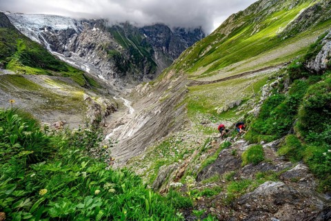 Two mountaineers on a hiking trail, dramatic mountain landscape with Grindelwald-Fiescherfirn