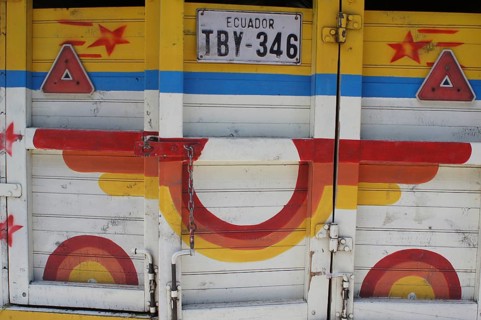 Close-up of a colorfully painted truck door, with Ecuadorian license plate and geometric patterns,