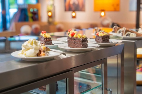 Vegan chocolaty desserts presented on white plates in a bakery counter, Cafe Kuh, Deckenpfronn,