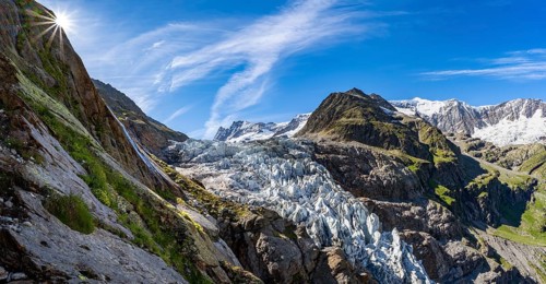 Mountain panorama, picturesque high alpine mountain landscape with Lower Eismeer glacier range, sun