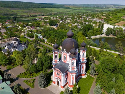 Extensive view of an Orthodox cathedral surrounded by green countryside and city, aerial view,