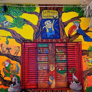 Colourful wall mural depicting a minion in a tree surrounded by cheerful animals and fruits,