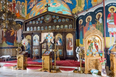 Orthodox church with ornate iconostasis and golden icons on a red carpet, Orthodox Church of Saint