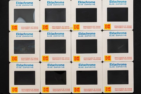 Rows of old neatly arranged Kodak Ektachrome 1980s 35mm slides mounted in white cardboard frames