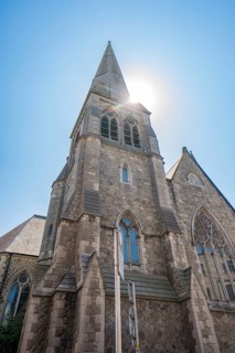 View of a church tower with Gothic architecture in sunlight, Dublin, Ireland