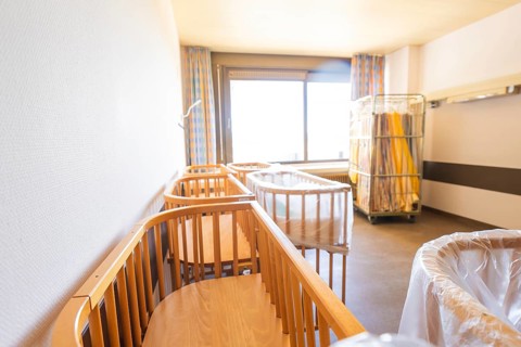 A bright room with several wooden cribs near a large window, Obstetrics, Nagold, Germany
