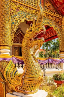 Decorated dragon figure in front of a prayer hall in the Wat Phra Singh Buddhist temple complex,