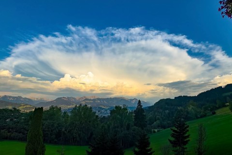 Hair dryer cloud dissolving over the edge of the Alps during a heat period during sunset, Bavaria,