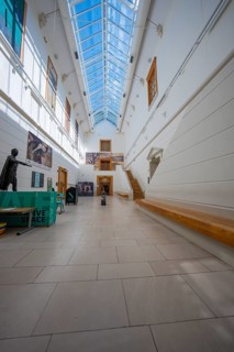 Light-flooded museum walkway with high ceiling and modern works of art on the walls, National