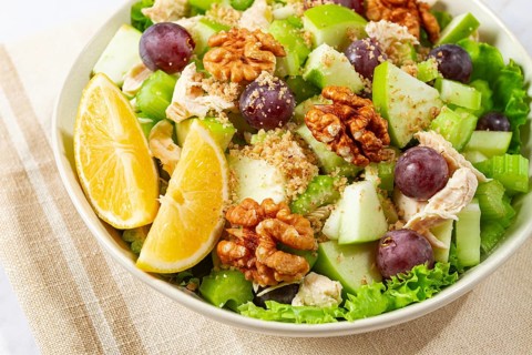 Fresh Waldorf salad, celery stalk with chicken, apple and walnuts, grapes, herbs, homemade, without