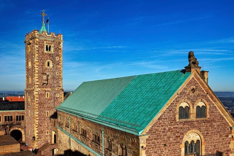 Castle on a hill with a distinctive tower and green roof, blue sky, The Wartburg near Eisenach in