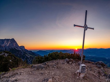 Sunrise at the summit cross of Rauhen Kopf, behind the Untersberg, Berchtesgaden Alps,