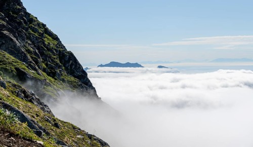 Mountain peaks above the clouds, mountain landscape and sea, view from the summit of