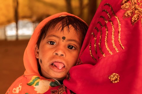 Portrait of a handicapped boy (Down syndrome) India . Photographed in his mother arms