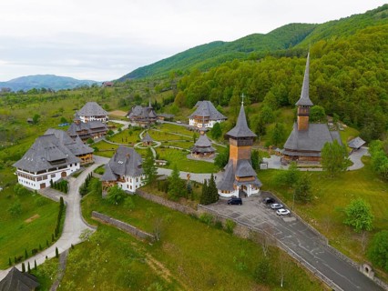 View of a quiet monastery with wooden structures surrounded by wooded hills, aerial view, Bârsana