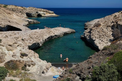 People swim in a sheltered bay with rocky shore and turquoise water, Kapras, Kapros, Beach, Kapros