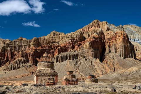 Buddhist stupas, including chords in front of an erosive landscape, red rocks near Dhakmar,