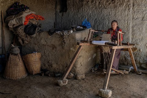 A woman works on her loom, traditional clay house, Choser, Mustang, Upper Mustang, former kingdom,