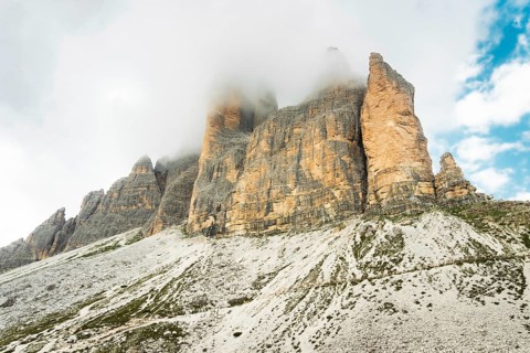 Dramatic misty Tre Cime di Lavaredo area. Dynamic clouds after rain move over the rugged limestone