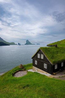 Traditional house with grass roof in the village of Bøur, Tindhólmur and Drangarnir, Vágar Island,