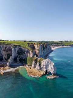 Aerial view of the Falaise d'Amont rock formation with the Porte d'Amont rock gate at low tide,