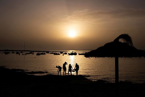 The sun sets on the horizon over the sea on the Spanish Balearic island of Majorca, Colonia de Sant